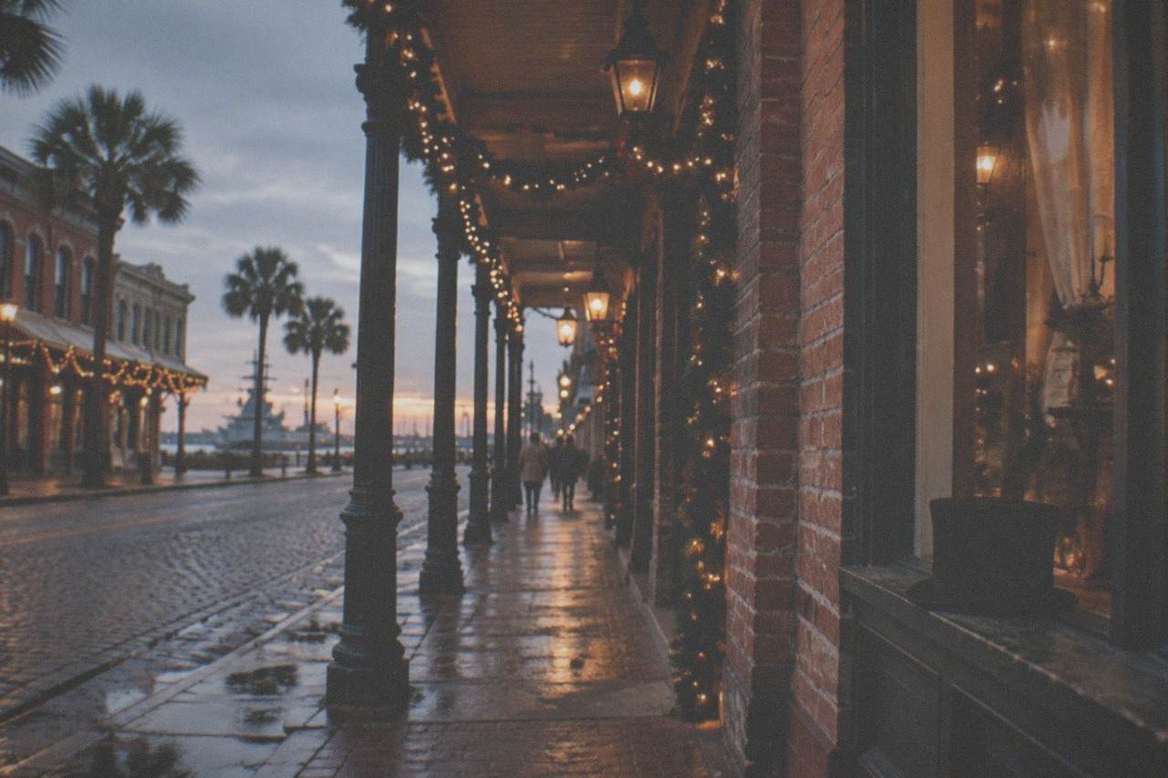 Victorian-style brick storefronts along a historic street lit for an evening festival