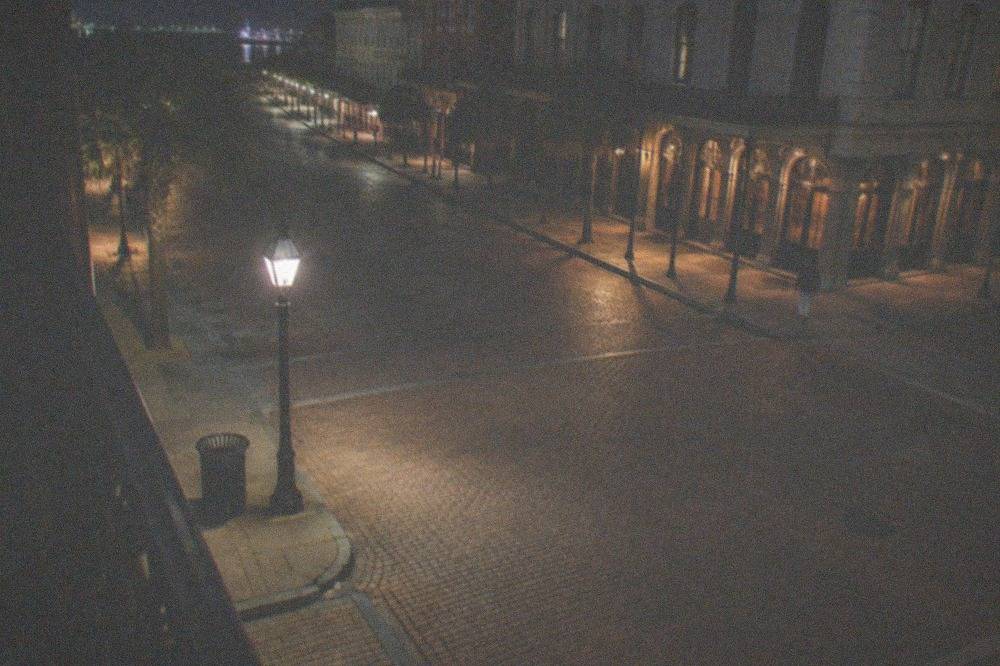 An empty Strand street corner under lamplight late at night