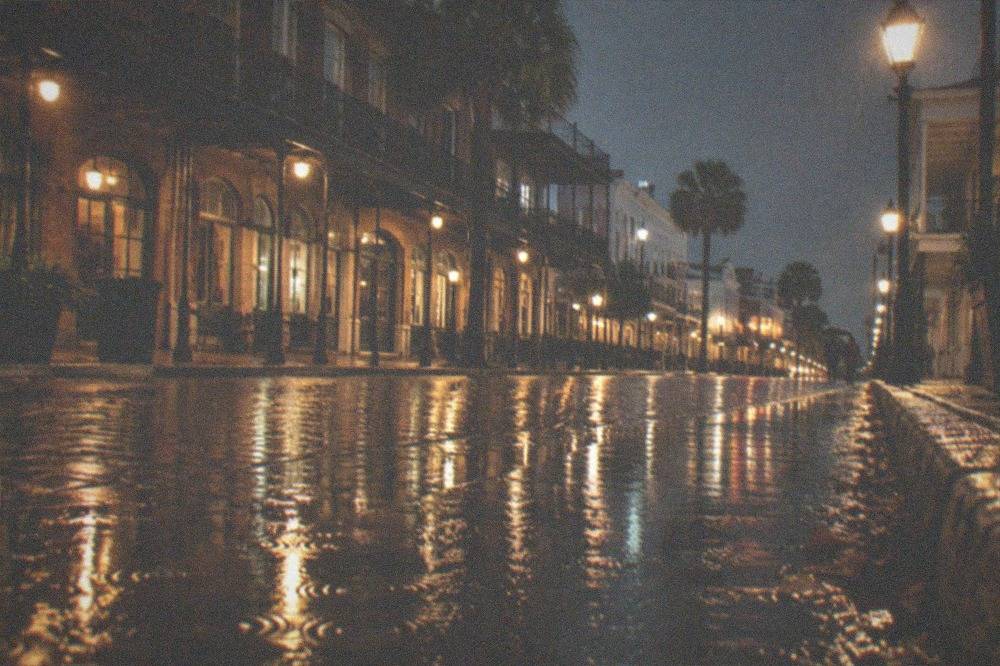 A wet Galveston street at night reflecting streetlights on brick pavement