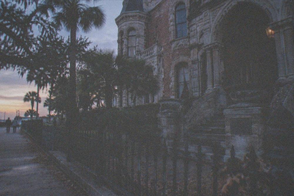 Historic Galveston building at dusk with a commemorative marker visible beside the entrance